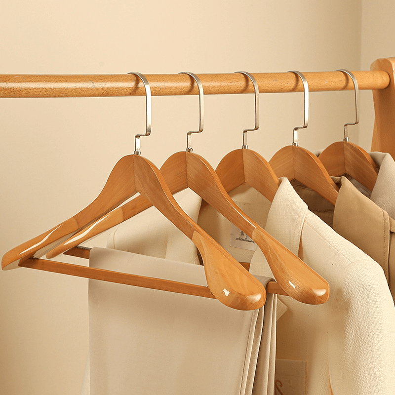 Cintre en bois courbé avec détails métalliques pour préserver la forme des vêtements - Hommfer